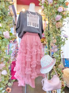 グレーのロゴ」Tシャツにピンクのフリルスカートを合わせた大人のスカートコーデ。淡いピンクのバッグと帽子を添えたLadies KAWAIの一点物スタイル