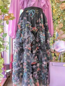 黒ベースの花柄チュールスカートにピンクブラウスを合わせた、大人の華やかスカートコーデ