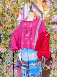 エターナリーブレイズのピンクトップスにブルーパンツを合わせた、大人の華やかコーデ。